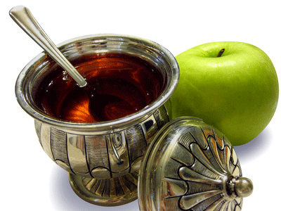 Apple and Honey served in a silver bowl. These fruits are the traditional symbols of Rosh Hashanah, representing the sweet new year to come